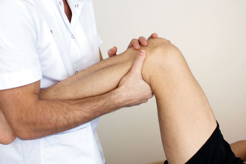 doctor examines the knee with osteoarthritis